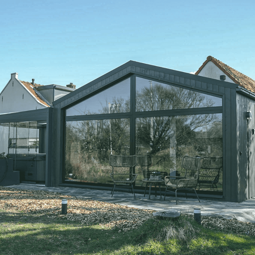Een stijlvolle pre-mantelzorgwoning met grote ramen, gelegen in een groene tuin, ideaal voor toekomstbestendige woonoplossingen.